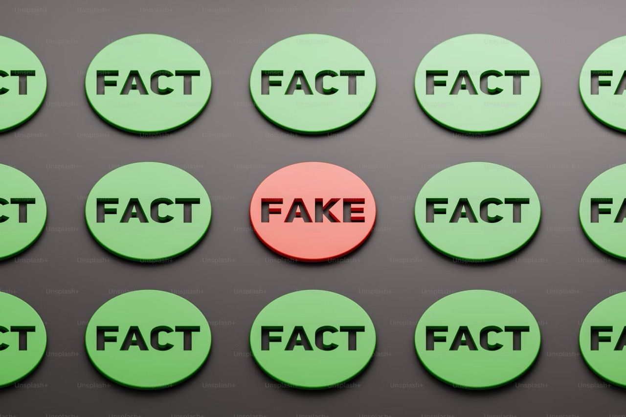 A grid of green circular tokens, each labeled "FACT," with a single red circular token in the center labelled "FAKE."