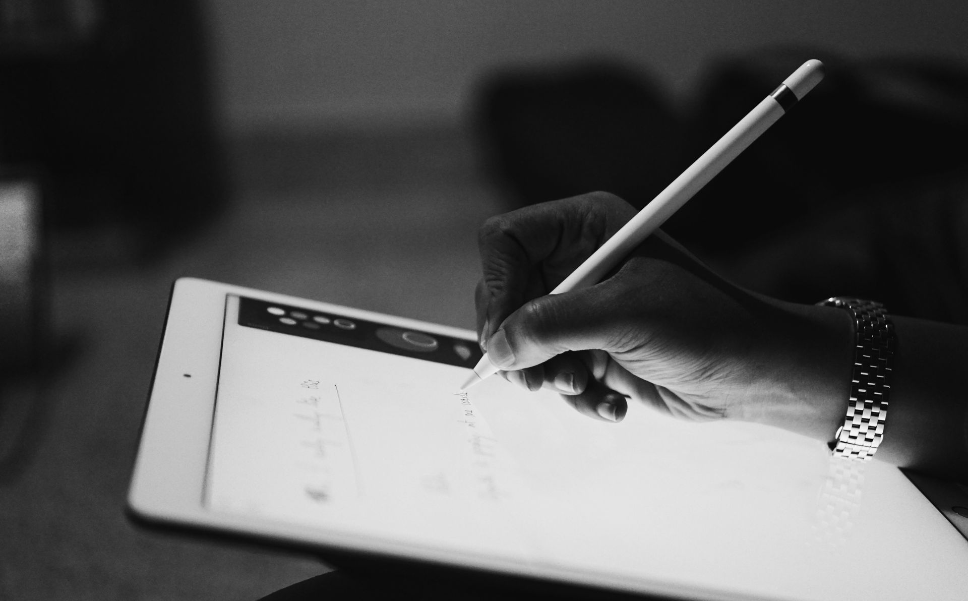 A woman writing notes, or a letter, on an iPad with an Apple Pencil